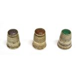 THREE THIMBLES comprising a continental stone set silver thimble, size 4, with a green moss agate