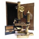 A BRASS MONOCULAR MICROSCOPE by W. Watson & Sons, London, serial number 23991, with three Bausch &