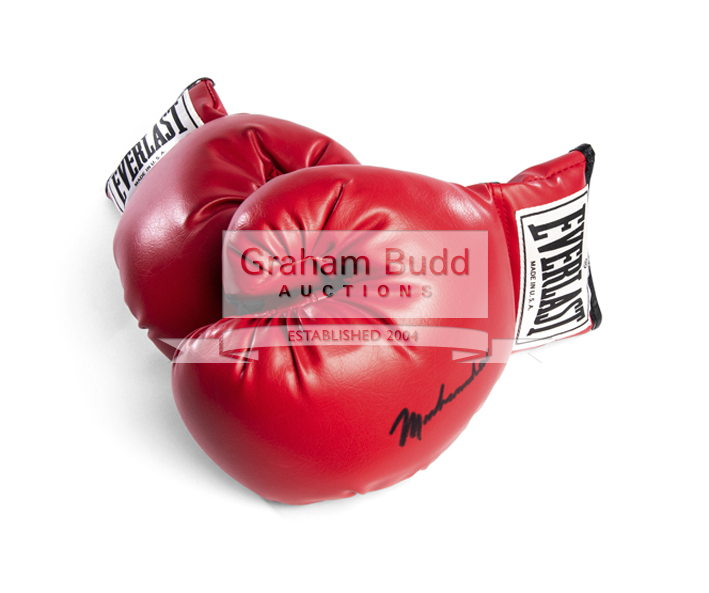 An autographed Muhammad Ali boxing glove, a pair of red leather Everlast boxing gloves,