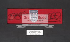 England football captain's armband double-signed by David Beckham and Michael Owen,