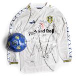 A Leeds United FC home replica jersey and a football, both autographed by the players, circa 2000,