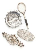 Three Victorian and later silver tennis brooches the first a circular brooch with racquet,