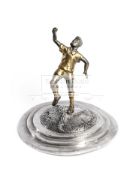 A bronze sculpture of Pele, with one fist raised in the classic post-goal celebratory pose,