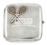 A continental silver cigarette case with crossed tennis racquets above a blue gemset ball,