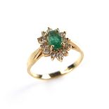 14 ct yellow gold emerald and diamond cluster ring. Set with an oval cut emerald surrounded by