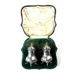 A pair of Edwardian silver pepper pots.