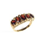 9 ct yellow gold five stone garnet ring. Set with five graduated oval cut garnets in an openwork