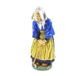 A French Henriot Qimper faience pottery figure of an old Breton woman, late 19th century.