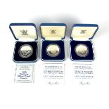 A group of three Royal Mint sterling silver proof commemorative coins.