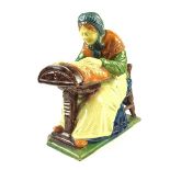 A French Henriot Qimper faience pottery figure of an old Breton woman, late 19th century.