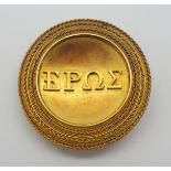 A BRIGHT YELLOW METAL BROOCH SPELLING OUT EROS IN GREEK in the antique style of the late Victorian