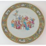 A CANTON CHARGER painted with scholars and attendants at a table within a dense gilt and