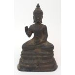 A BRONZE MODEL OF BUDDHA seated in lotus position with outstretched arm and holding a vessel on a