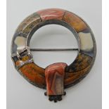 A SCOTTISH AGATE INLAID PLAID BROOCH in a buckled garter shape set with specimen agates.