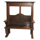 AN ARTS AND CRAFTS MAHOGANY HALL SETTLE the shaped back with carved tendrils flanked by scroll arm
