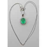 A PLATINUM EMERALD AND DIAMOND CLUSTER PENDANT BY RHAPSODY the central emerald is approx 9.2mm x 7.
