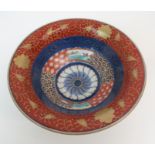 A CHINESE IMARI BOWL the interior painted with landscape vignettes within cell pattern and blue, red