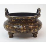 A CHINESE BRONZE GOLD SPLASHED CENSER with a pair of loop handles above a short shoulder cast with