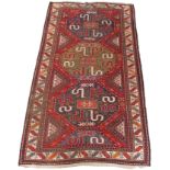 A RED GROUND CAUCASIAN RUG with three central medallions with stylised animals