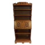 A VICTORIAN OAK BUREAU BOOKCASE with three open shelves above a carved fall flap enclosing pigeon