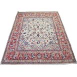 A NAJAF ABAD IVORY GROUND RUG with all-over foliate design with main red border, 330cm x 265cm