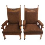 A PAIR OF ARTS AND CRAFTS OAK ARMCHAIRS with carved backs on square tapering legs, 116cm high (2)