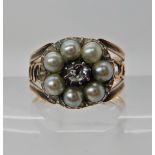 A ROSE COLOURED METAL RING SET WITH AN OLD CUT DIAMOND AND PEARLS in the Georgian style, finger size