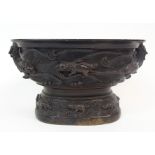 A CHINESE BRONZE CENSER cast with grotesque animals on waves with fish handles, raised on a domed