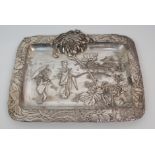 A JAPANESE ELECTROPLATED PEWTER TRAY cast with ladies before a village and within a dense foliate