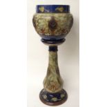A ROYAL DOULTON STONEWARE JARDINIERE AND STAND with moulded and glazed stylised floral decoration,