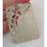 A CHINESE JADE PENDANT carved with shou characters surrounded by a bird and foliage, 5.8cm x 4cm