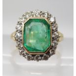 AN 18CT GOLD EMERALD AND DIAMOND RING WITH FLEUR DE LIS SHOULDERS set with estimate approx 0.56cts