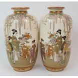 A PAIR OF SATSUMA VASES painted with ladies and children beneath wisteria and amongst flowers,