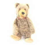 AN EARLY STIEFF TEDDY BEAR with stitched muzzle, paws and claws, with button and remains of label,