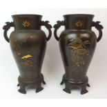 A PAIR OF JAPANESE BRONZE TWO-HANDLED BALUSTER VASES decorated with peonies issuing from rockwork