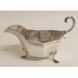 A SILVER SAUCEBOAT by James Aitchison, London 1909, the faceted body with open scrolling handle