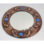 A COPPER ARTS AND CRAFTS WALL MIRROR of circular shape, with hammered and stylised decoration with