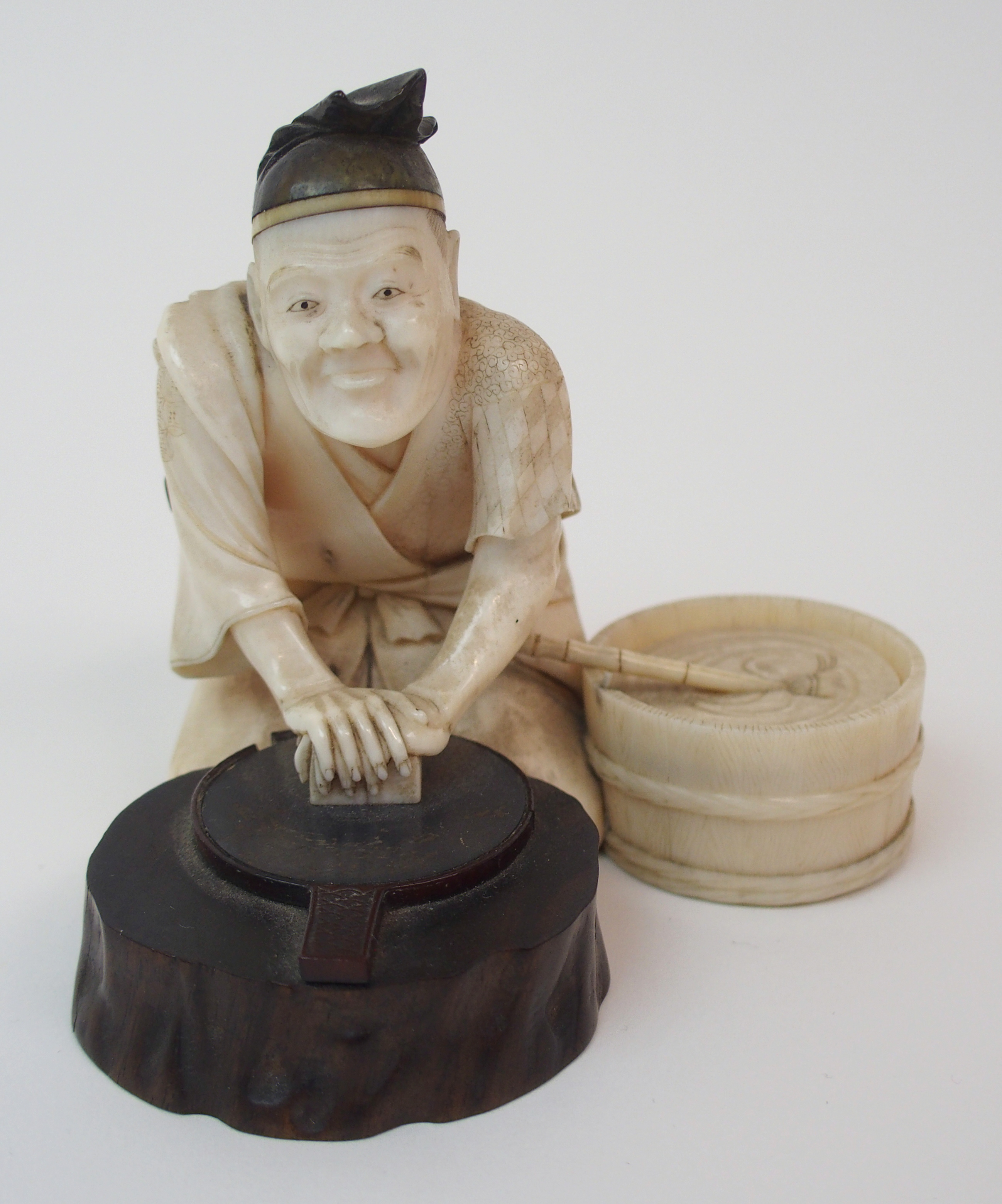 AN IVORY, WOOD AND METAL OKIMONO OF A MIRROR MAKER kneeling and polishing a mirror on a tree