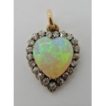 A FIERY WHITE OPAL AND DIAMOND HEART SHAPED PENDANT mounted in yellow and white metal, old cut