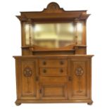 AN OAK ARTS AND CRAFTS MIRROR BACK SIDEBOARD with carved top above shaped mirror with pedestal