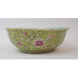A CHINESE YELLOW GROUND FRILLED BOWL exterior with peonies and scrolling foliage, Qianlong seal mark