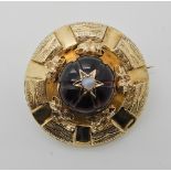 A BRIGHT YELLOW METAL VICTORIAN LOCKET BACK BROOCH set with a carved garnet colour gem, set
