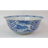 A CHINESE BLUE AND WHITE BOWL painted with panels of landscapes divided by foliage, the interior