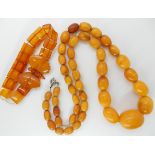 A string of amber coloured beads and an amber coloured butterfly bracelet weight for both approx