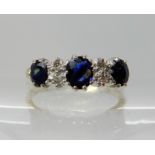An 18ct gold sapphire and diamond linear cluster ring, zoning visible in the sapphires largest