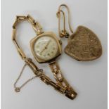 A 9ct gold ladies vintage watch, weight including mechanism 14gms and a yellow metal locket