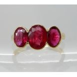 An 18ct gold three stone ruby ring, rubies approx 8mm x 6mm x 3.3mm and two at approx 7mm x 5mm x