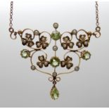 A yellow metal Edwardian pendant with peridot and pearl set shamrocks, gem set area 3.7cm x 4cm,