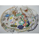 A bag full of vintage costume jewellery to include a glass bird necklace, Deco clips Czech glass etc