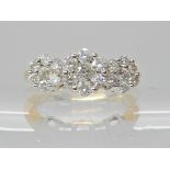 A 14k gold ring set with three diamond flowers, to an estimated approx combined diamond total of